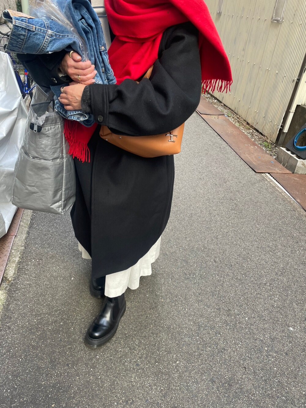 ブラック系のジャケット/アウター、ブラック系のブーツ、ホワイト系のワンピースを着用したレディースの冬コーディネートの2枚目の写真