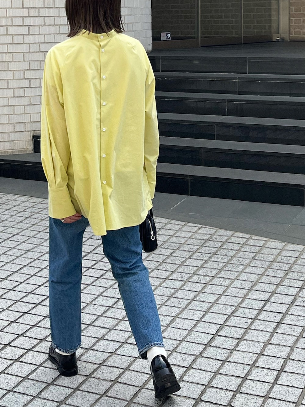 イエロー系のシャツ/ブラウス、ブラック系のボストンバッグ、ブラック系のローファーを着用したレディースの春コーディネートの4枚目の写真