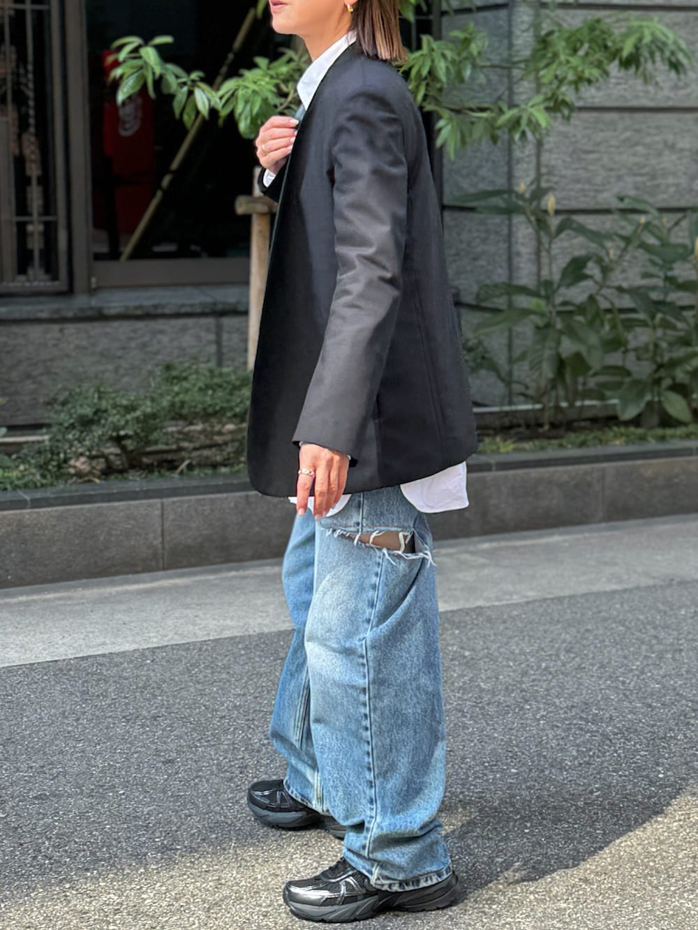 ホワイト系のシャツ/ブラウス、ブラック系のノーカラージャケット、ブラック系のスニーカーを着用したレディースの春コーディネートの3枚目の写真