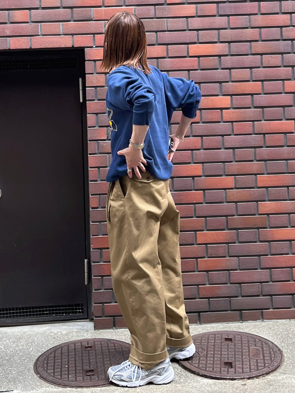 ベージュ系のチノパンツ、グレー系のスニーカー、シルバー系のブレスレットを着用したレディースの夏コーディネートの2枚目の写真