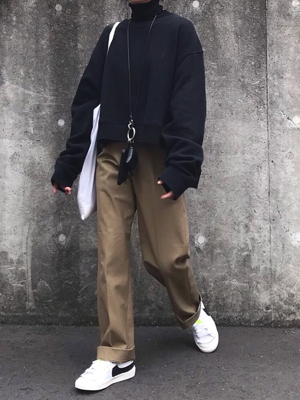 ベージュ系のチノパンツ、ホワイト系のスニーカーを着用したレディースの冬コーディネートの3枚目の写真