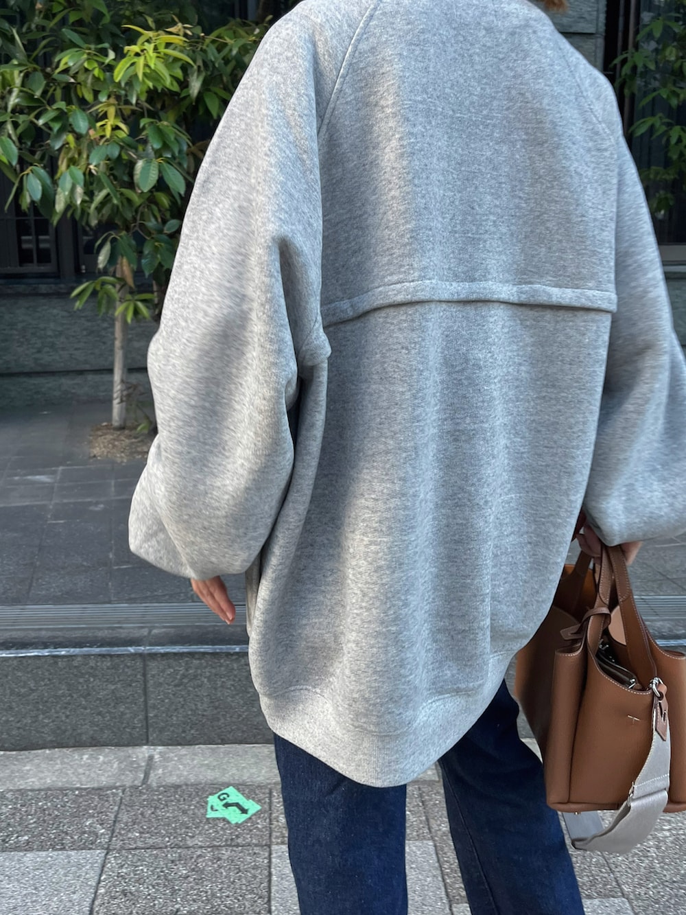 グレー系のスウェット、ブラック系のスリッポン、シルバー系のピアス（両耳用）を着用したレディースの秋コーディネートの3枚目の写真