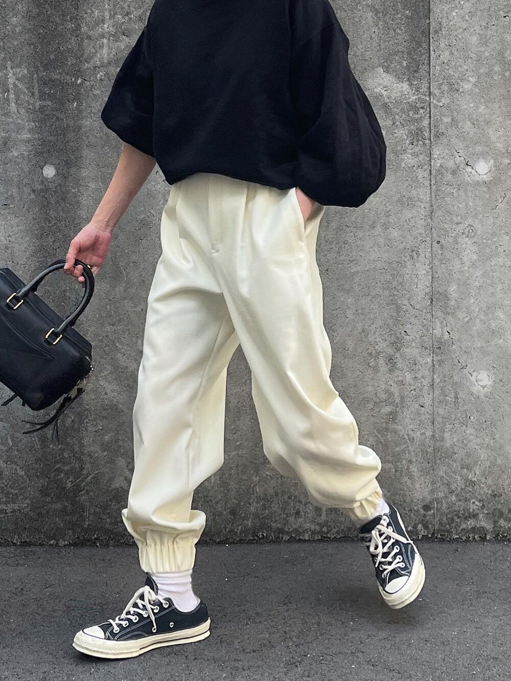 ホワイト系のパンツ、ブラック系のショルダーバッグを着用したレディースの秋コーディネートの4枚目の写真