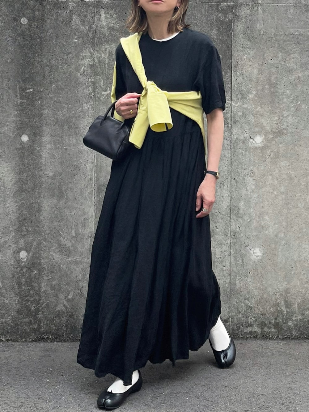 イエロー系のシャツ/ブラウス、ブラック系のサンダル、ブラック系のバレエシューズを着用したレディースの春コーディネートの2枚目の写真