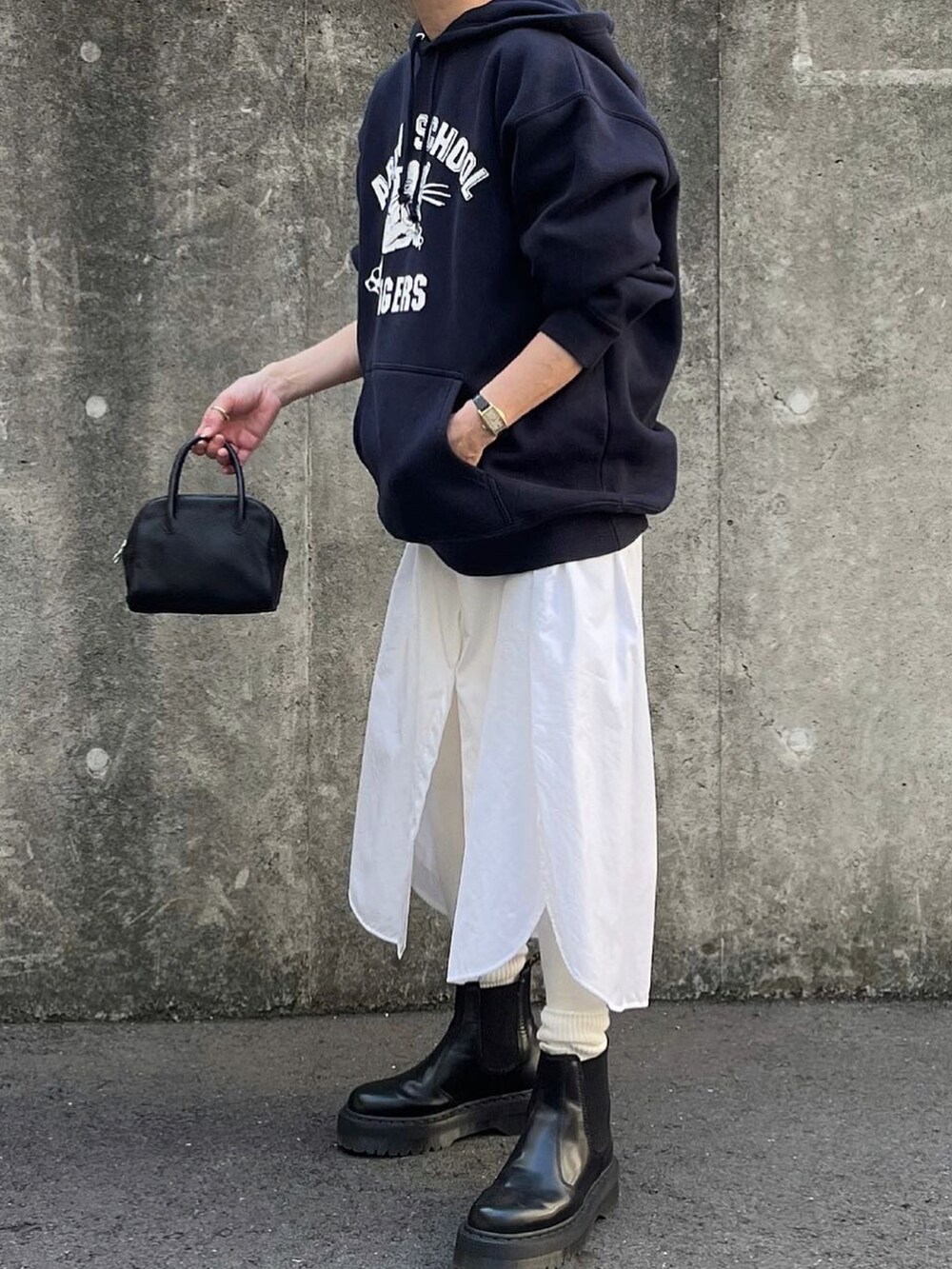 ホワイト系のシャツワンピース、ブラック系のボストンバッグ、ブラック系のブーツを着用したレディースの冬コーディネートの2枚目の写真