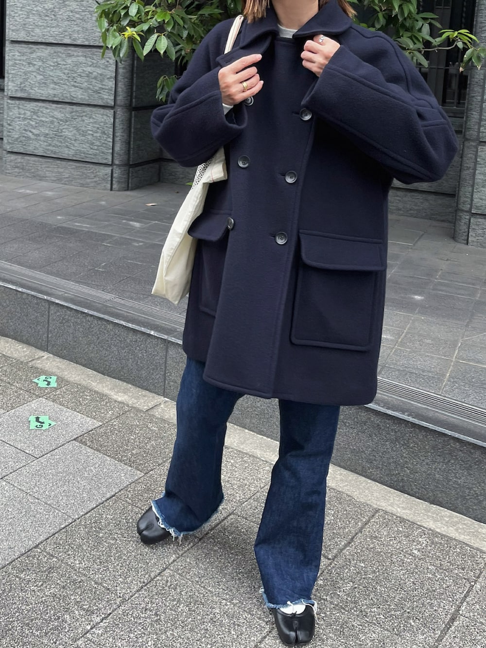 ブラック系のバレエシューズ、ブルー系のピーコート、シルバー系のピアス（両耳用）を着用したレディースの秋コーディネートの4枚目の写真