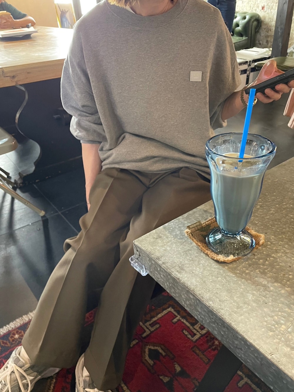 グレー系のスウェット、グリーン系のパンツ、グレー系のスニーカーを着用したレディースの夏コーディネートの3枚目の写真