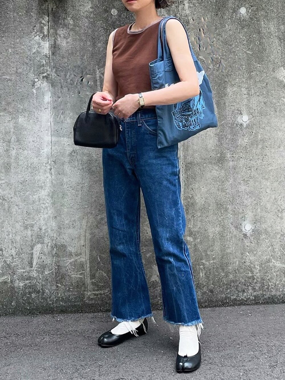 ブラウン系のTシャツ/カットソー、ブラック系のボストンバッグ、ブルー系のトートバッグを着用したレディースの夏コーディネートの3枚目の写真