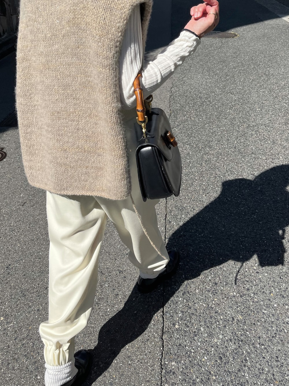 ホワイト系のパンツ、ブラック系のローファー、ブラウン系のストール/ショールを着用したレディースの秋コーディネートの4枚目の写真