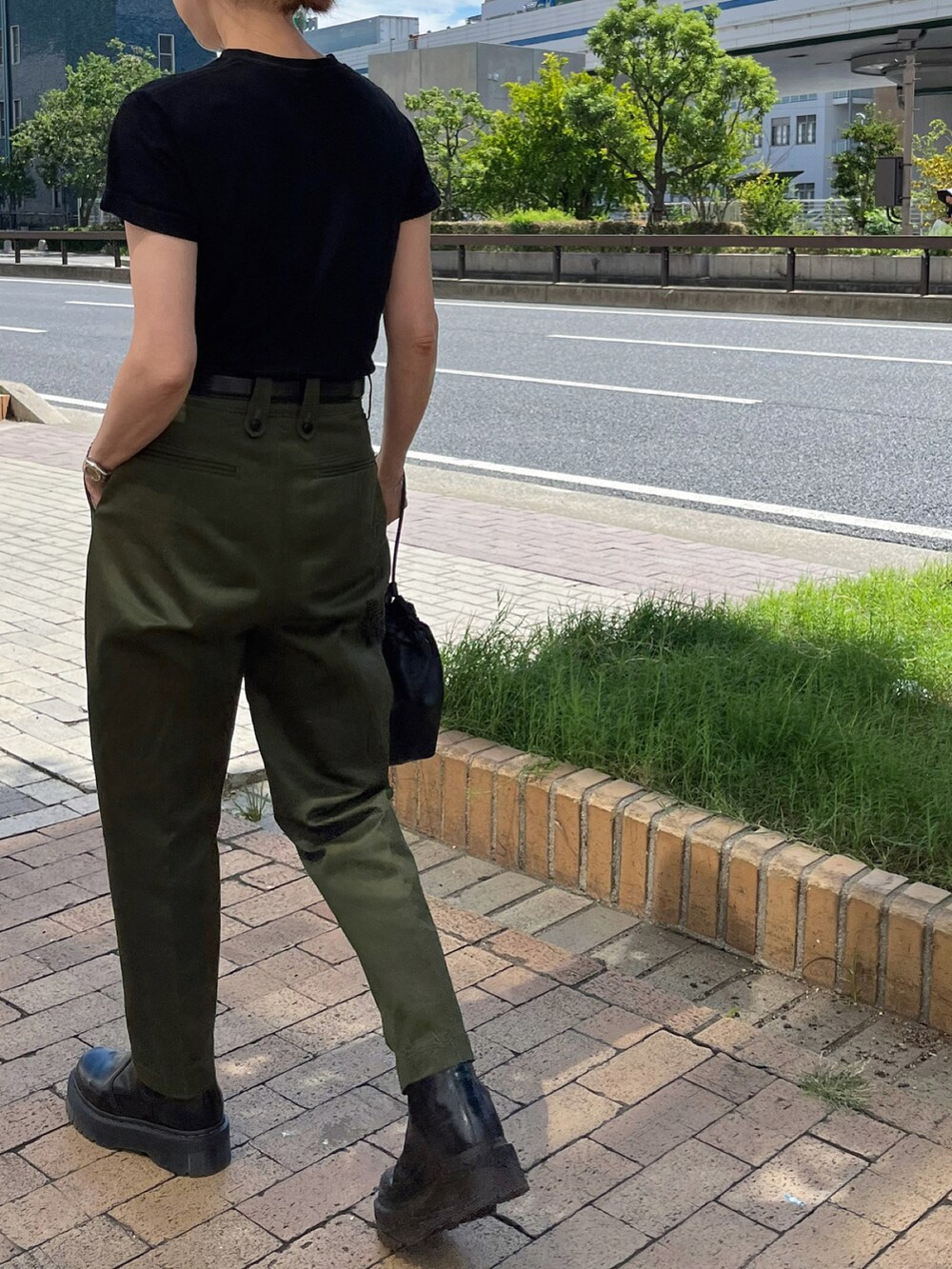 グリーン系のパンツ、ブラック系のブーツ、シルバー系のブレスレットを着用したレディースの秋コーディネートの4枚目の写真