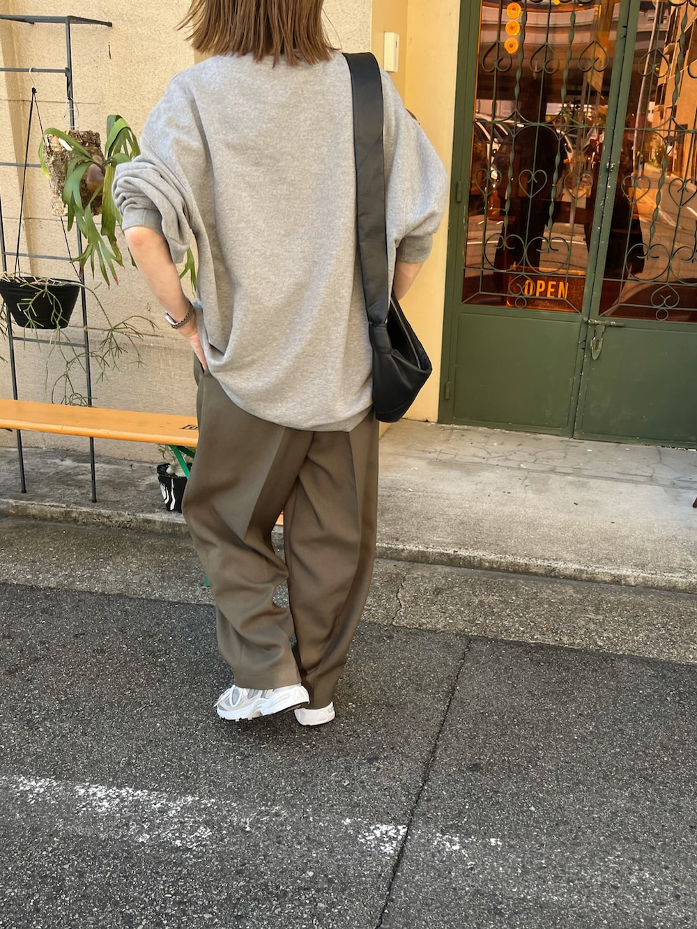 グレー系のスウェット、グリーン系のパンツ、グレー系のスニーカーを着用したレディースの夏コーディネートの2枚目の写真