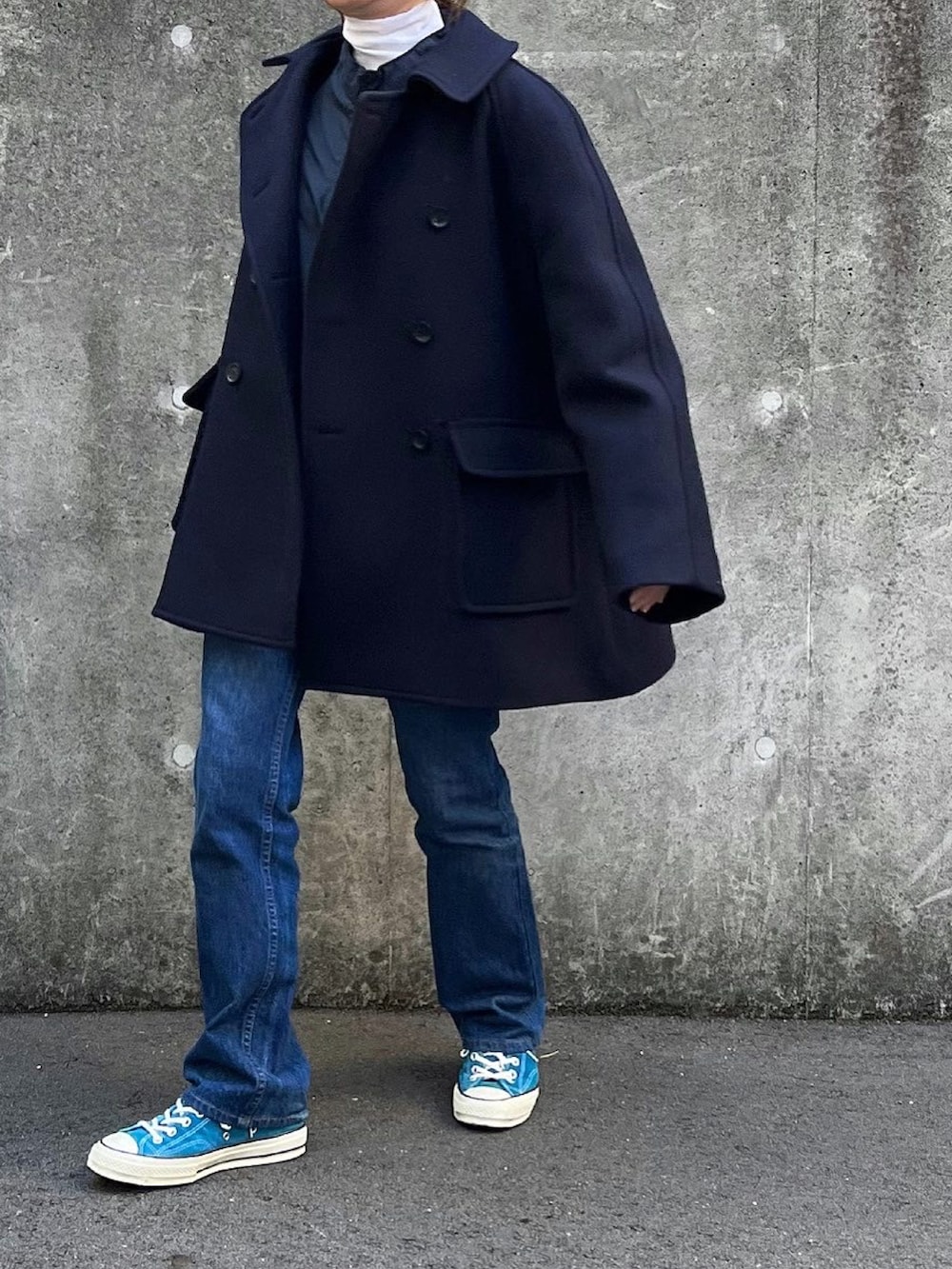 ブルー系のピーコート、ホワイト系のTシャツ/カットソー、ブラック系のボストンバッグを着用したレディースの冬コーディネートの2枚目の写真