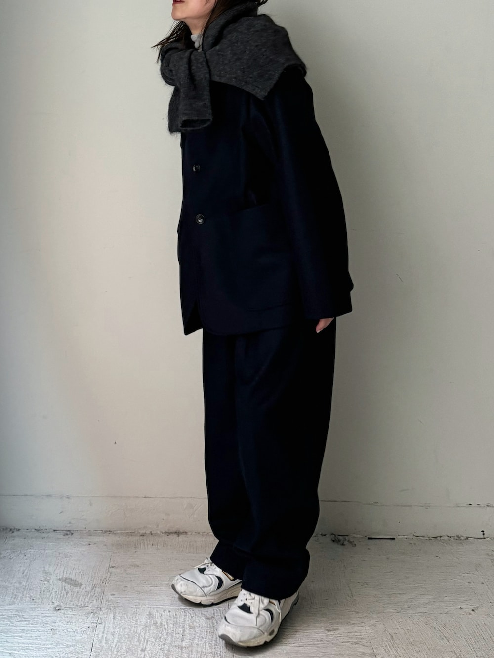 ブラック系のテーラードジャケット、ブラック系のスラックス、グレー系のカーディガン/ボレロを着用したレディースの秋コーディネートの5枚目の写真