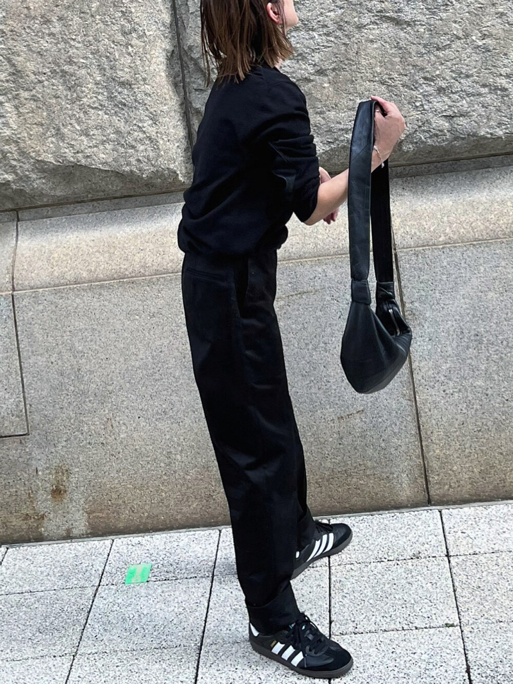 ブラック系のニット/セーター、ブラック系のショルダーバッグ、ブラック系のパンツを着用したレディースの秋コーディネートの2枚目の写真