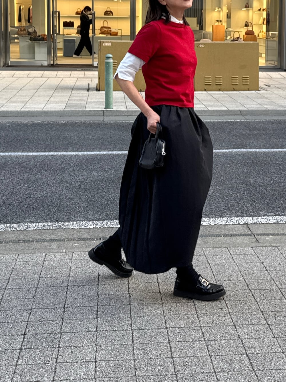 レッド系のニット/セーター、ブラック系のスカートを着用したレディースの冬コーディネートの3枚目の写真