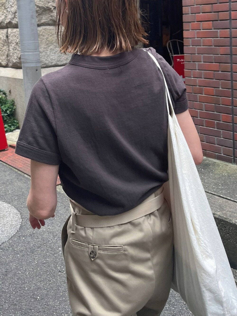 ブラウン系のTシャツ/カットソー、ベージュ系のその他パンツ、ブラック系のサンダルを着用したレディースの夏コーディネートの3枚目の写真