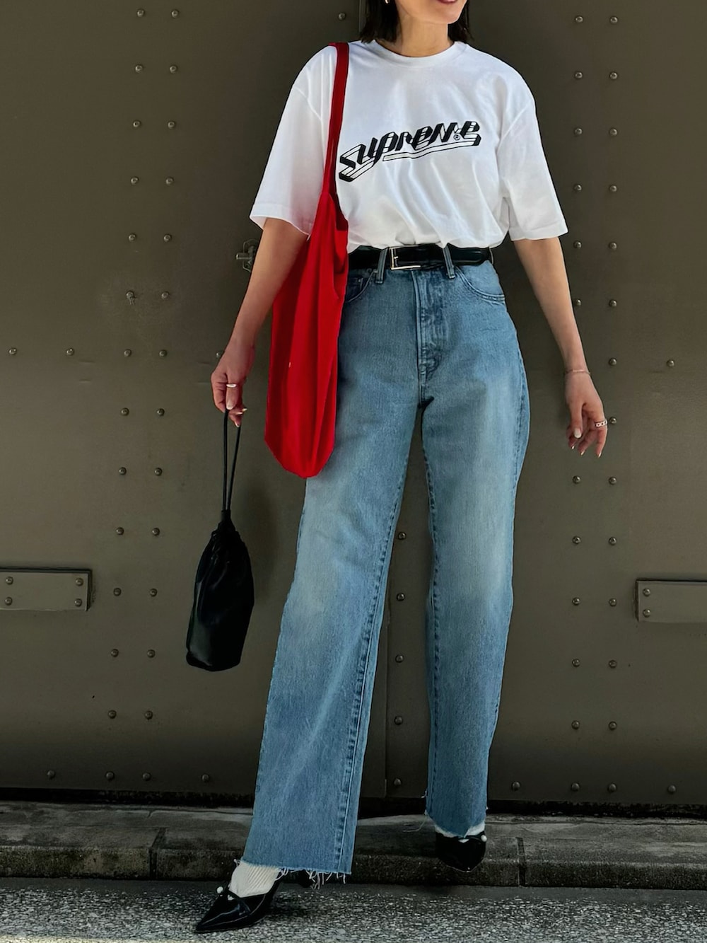 ブルー系のデニムパンツ、ブラック系のパンプス、シルバー系のブレスレットを着用したレディースの春コーディネートの2枚目の写真