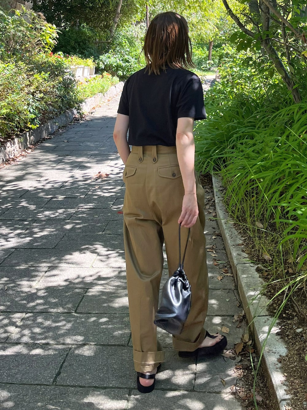 ブラック系のTシャツ/カットソー、ベージュ系のチノパンツを着用したレディースの夏コーディネートの4枚目の写真