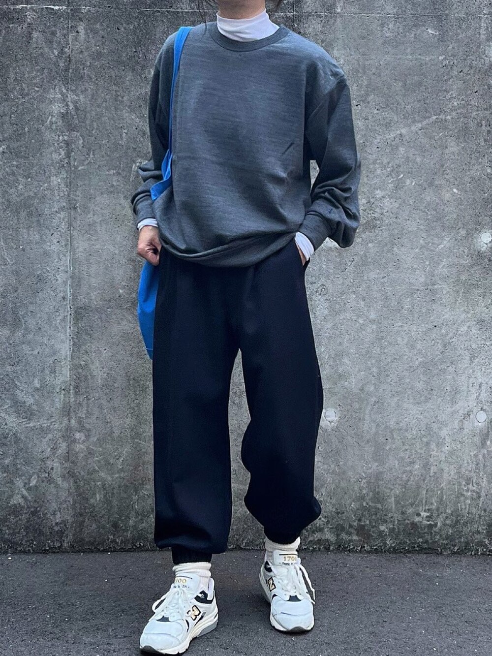 グレー系のトップス、ホワイト系のTシャツ/カットソー、ブルー系のスラックスを着用したレディースの冬コーディネートの3枚目の写真