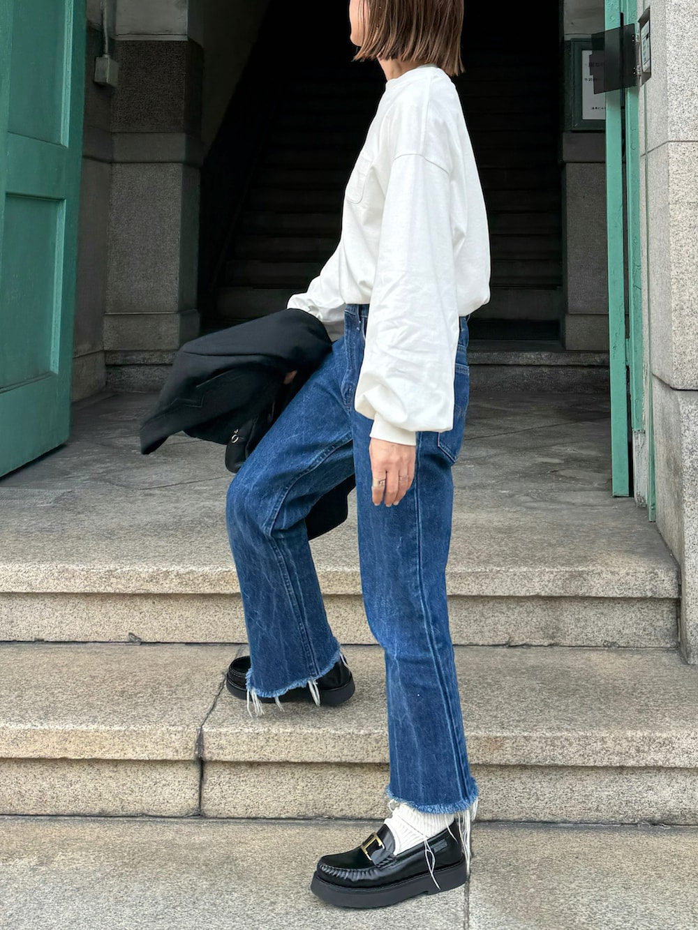 ホワイト系のTシャツ/カットソー、ブラック系のテーラードジャケット、ブラック系のローファーを着用したレディースの冬コーディネートの3枚目の写真