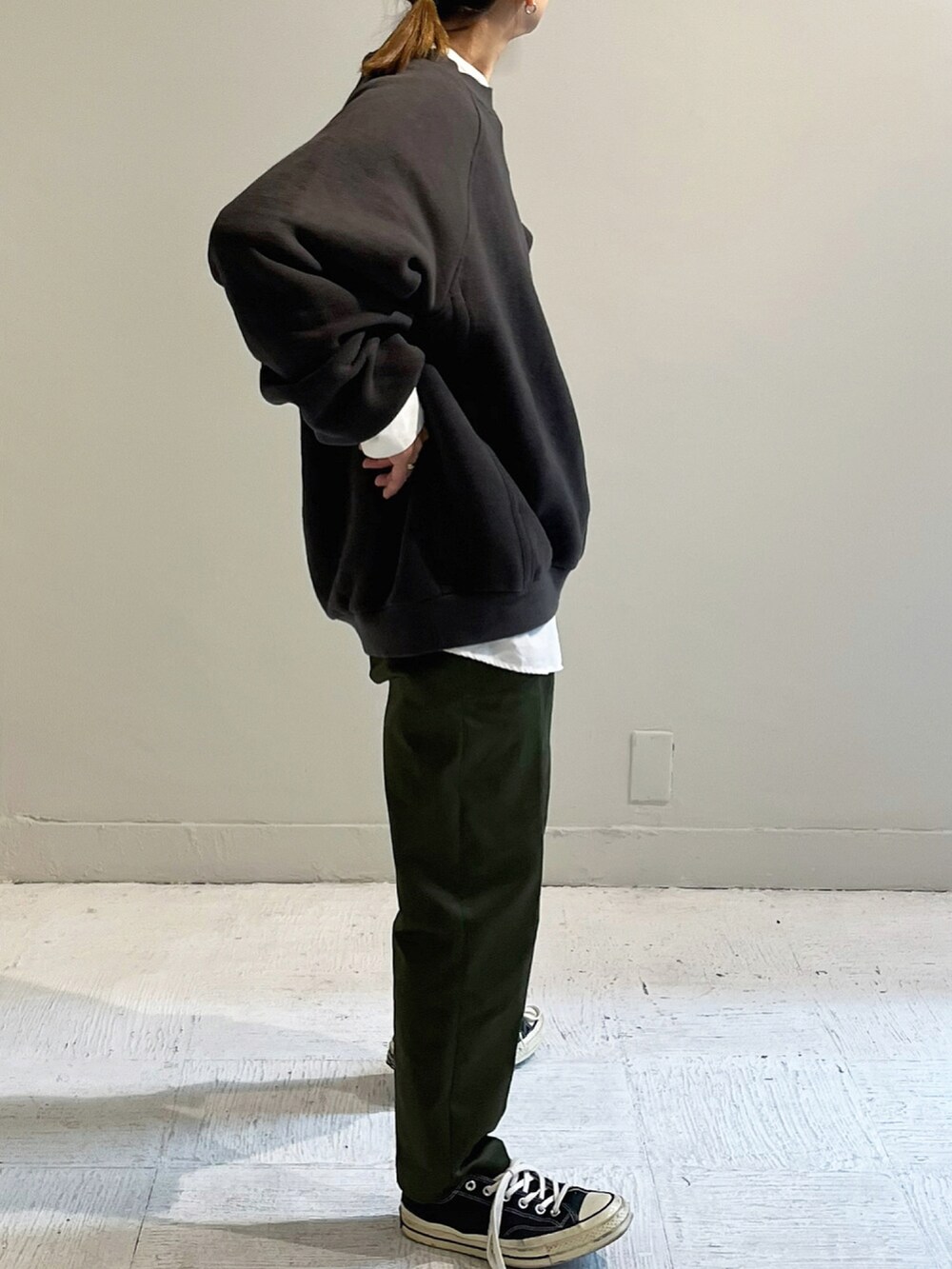 ブラック系のスウェット、グリーン系のパンツ、シルバー系のピアス（両耳用）を着用したレディースの秋コーディネートの2枚目の写真