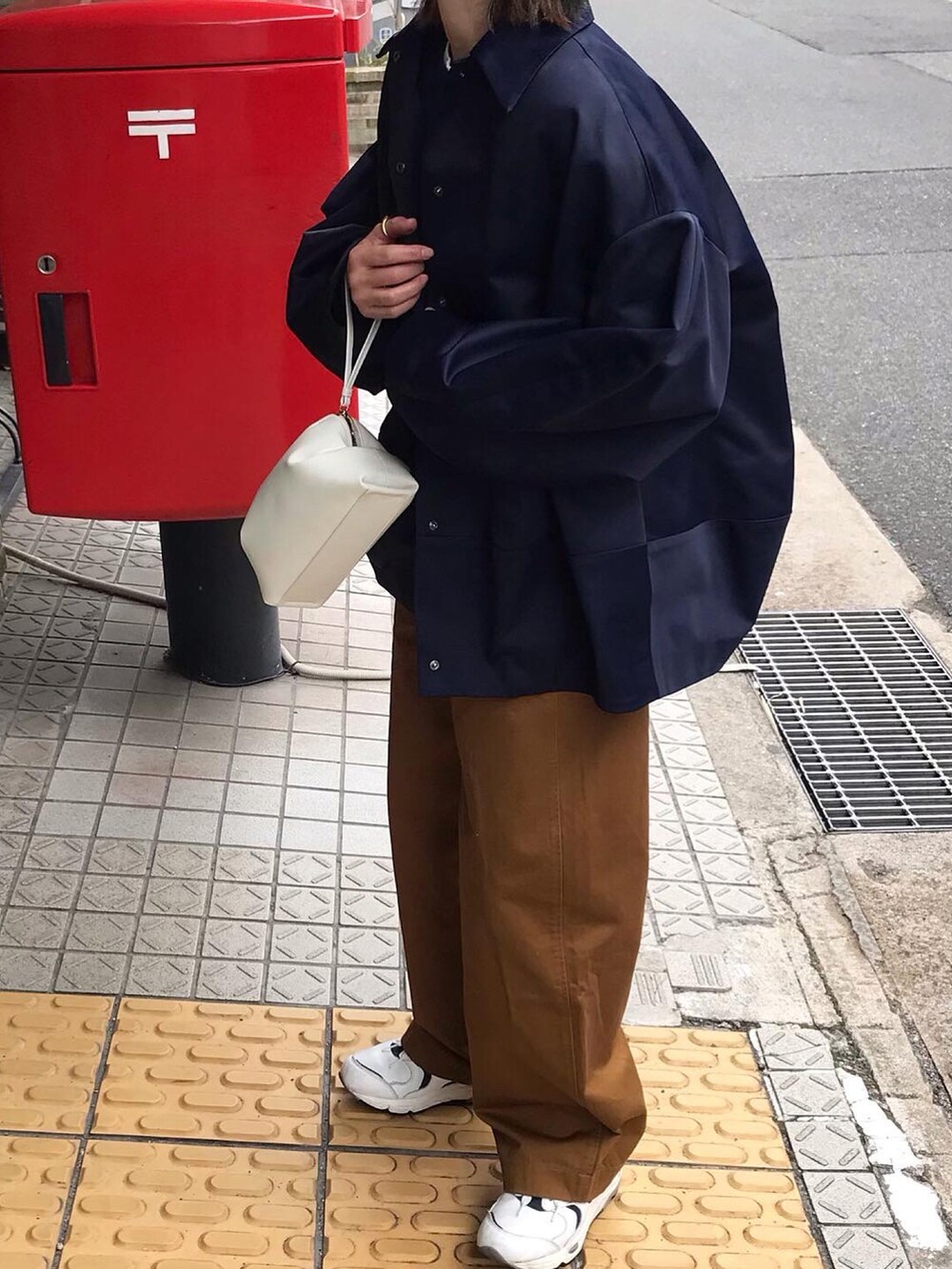 ホワイト系のショルダーバッグ、ホワイト系のスニーカーを着用したレディースの春コーディネートの2枚目の写真