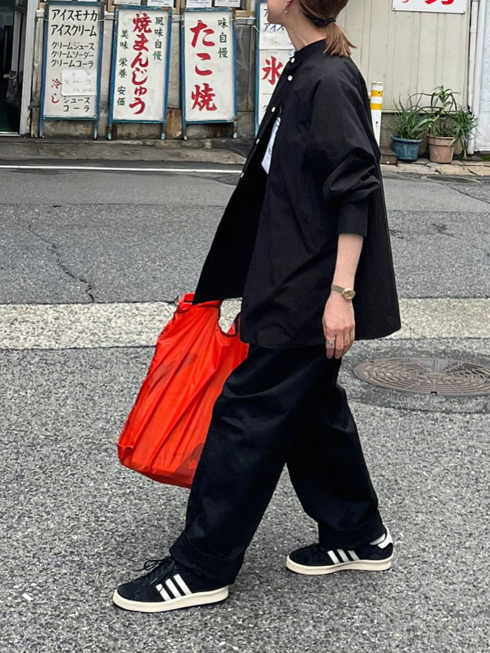 ブラック系のシャツ/ブラウス、ブラック系のチノパンツ、ブラック系のスニーカーを着用したレディースの春コーディネートの4枚目の写真