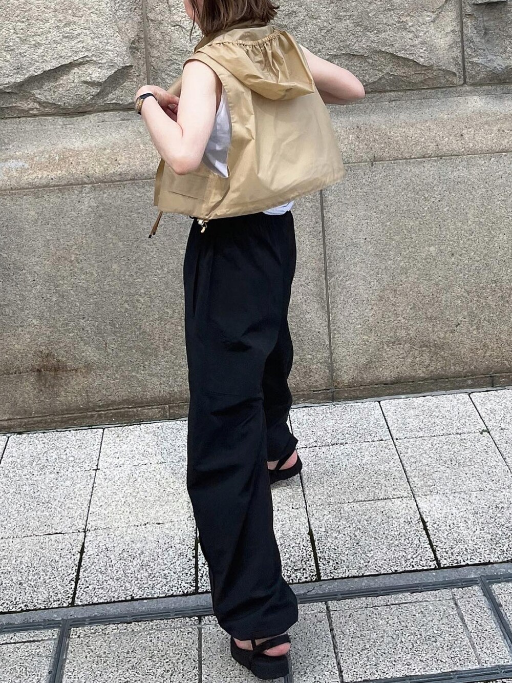 ホワイト系のタンクトップ、ブラック系のパンツ、シルバー系のブレスレットを着用したレディースの夏コーディネートの3枚目の写真
