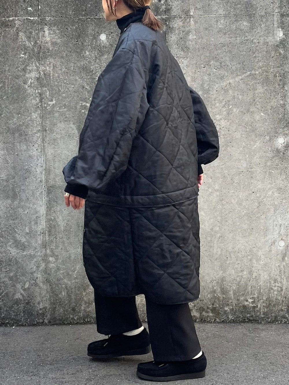 ブラック系のジャケット/アウター、ブラック系のモカシン/デッキシューズ、ブラウン系のストール/ショールを着用したレディースの冬コーディネートの2枚目の写真