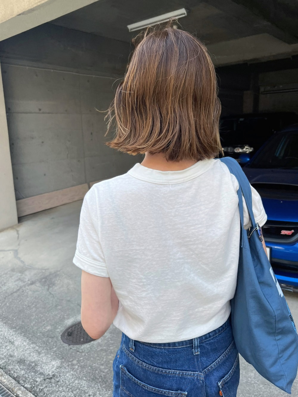 ホワイト系のTシャツ/カットソー、ブルー系のトートバッグ、ブラック系のサンダルを着用したレディースの夏コーディネートの4枚目の写真