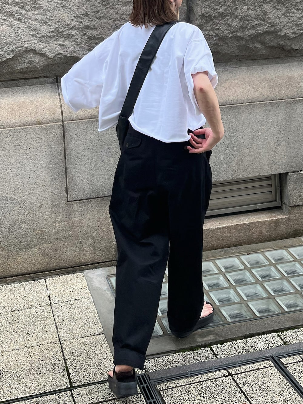 ブラック系のチノパンツ、ブラック系のサンダル、ブラック系のショルダーバッグを着用したレディースの夏コーディネートの4枚目の写真