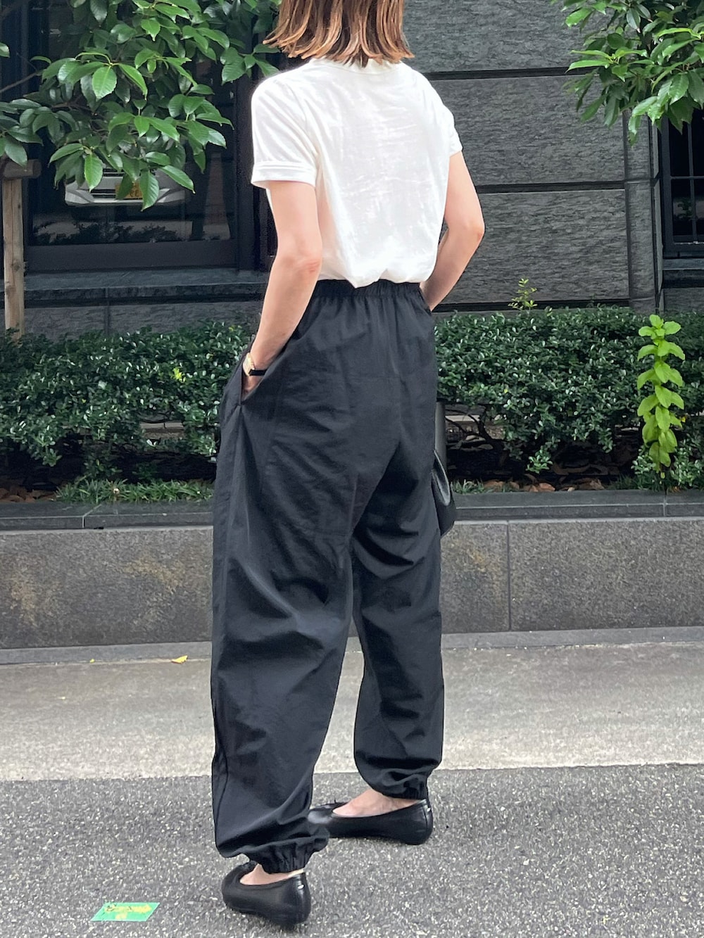 ホワイト系のTシャツ/カットソー、ブラック系のパンツ、ブラック系のバレエシューズを着用したレディースの夏コーディネートの4枚目の写真