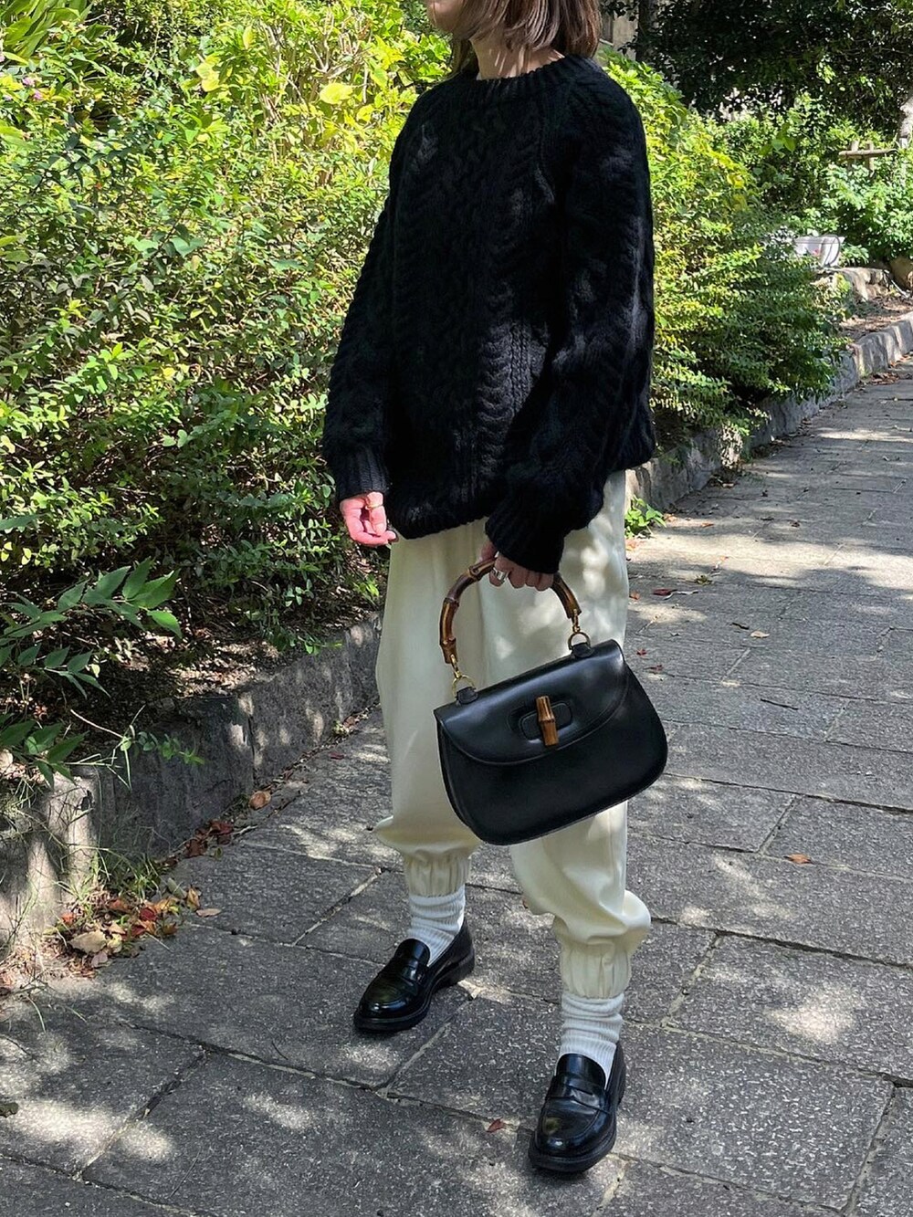 ブラック系のニット/セーター、ホワイト系のパンツ、ブラック系のローファーを着用したレディースの秋コーディネートの3枚目の写真