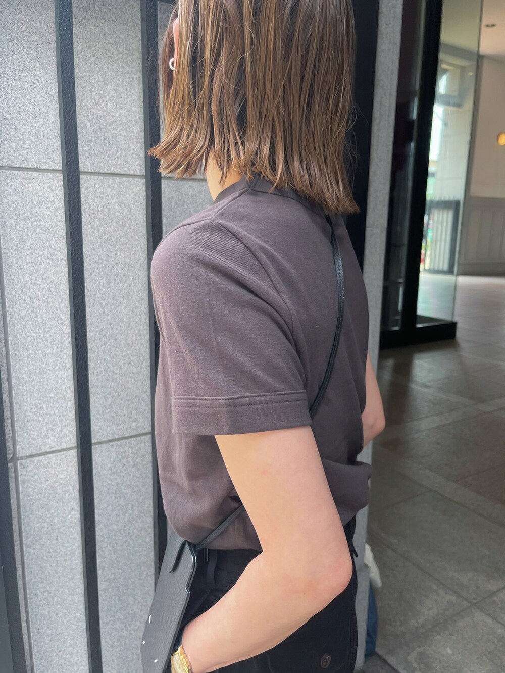 ブラウン系のTシャツ/カットソー、ブラック系のチノパンツ、ブラック系のサンダルを着用したレディースの夏コーディネートの4枚目の写真