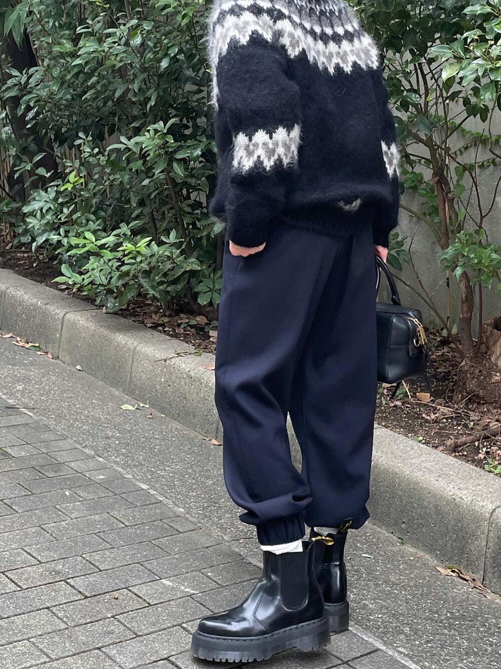 ブラック系のニット/セーター、ブルー系のスラックスを着用したレディースの秋コーディネートの5枚目の写真