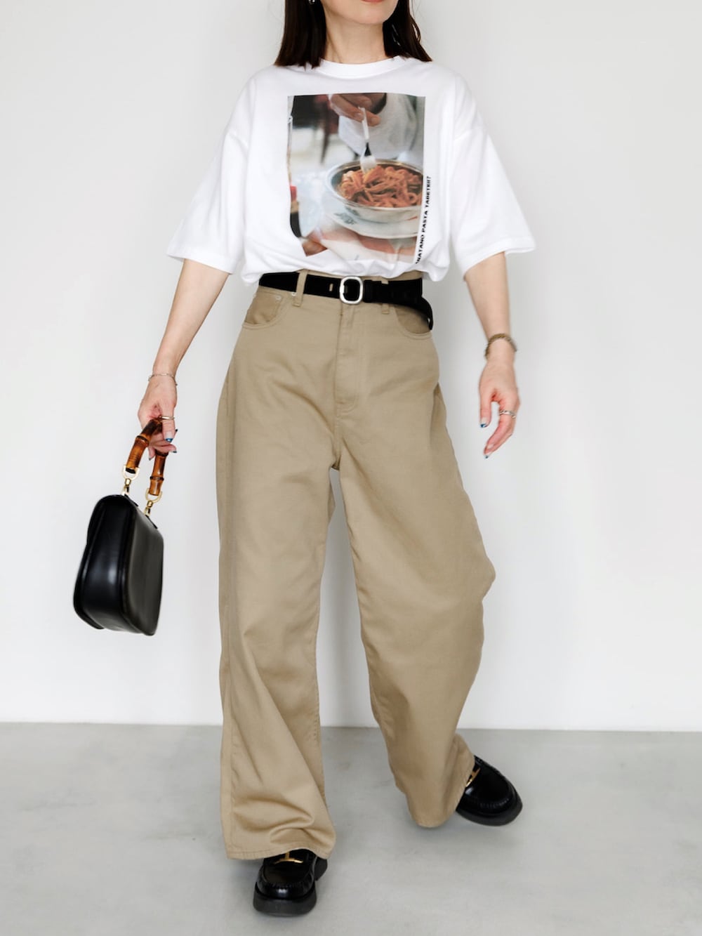 ホワイト系のTシャツ/カットソー、ベージュ系のチノパンツ、シルバー系のブレスレットを着用したレディースの春コーディネートの2枚目の写真