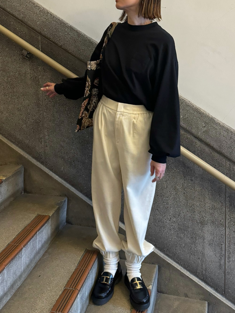 ブラック系のTシャツ/カットソー、ホワイト系のパンツ、ブラック系のローファーを着用したレディースの冬コーディネートの2枚目の写真