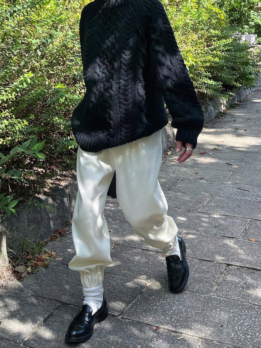 ブラック系のニット/セーター、ホワイト系のパンツ、ブラック系のローファーを着用したレディースの秋コーディネートの2枚目の写真