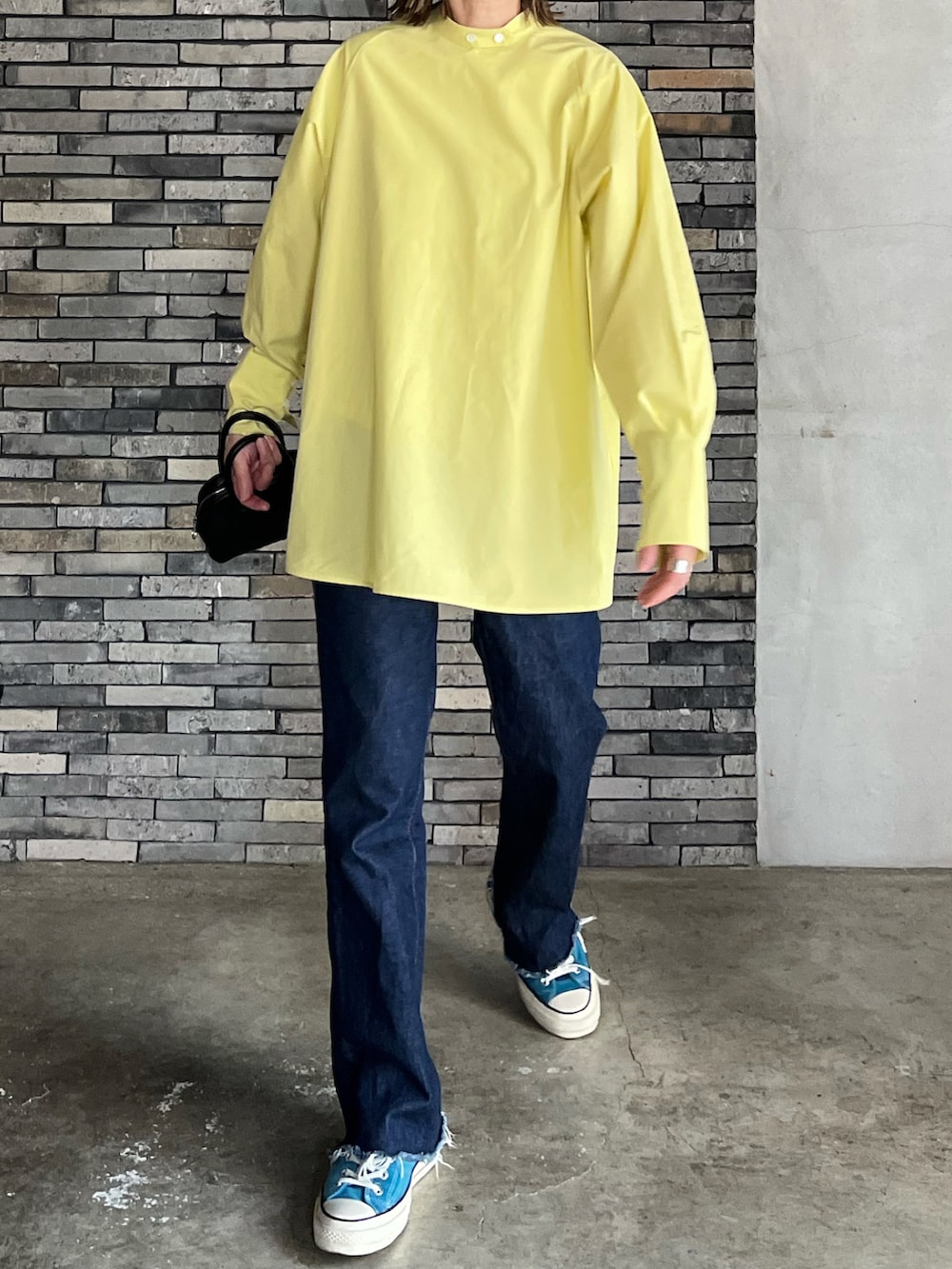 イエロー系のシャツ/ブラウス、ブラック系のボストンバッグ、ブラック系のローファーを着用したレディースの春コーディネートの5枚目の写真