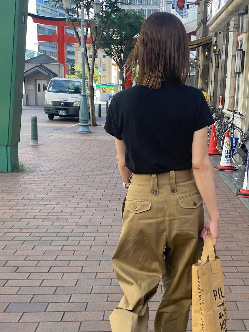 ベージュ系のチノパンツ、ブラック系のサンダル、シルバー系のブレスレットを着用したレディースの夏コーディネートの5枚目の写真
