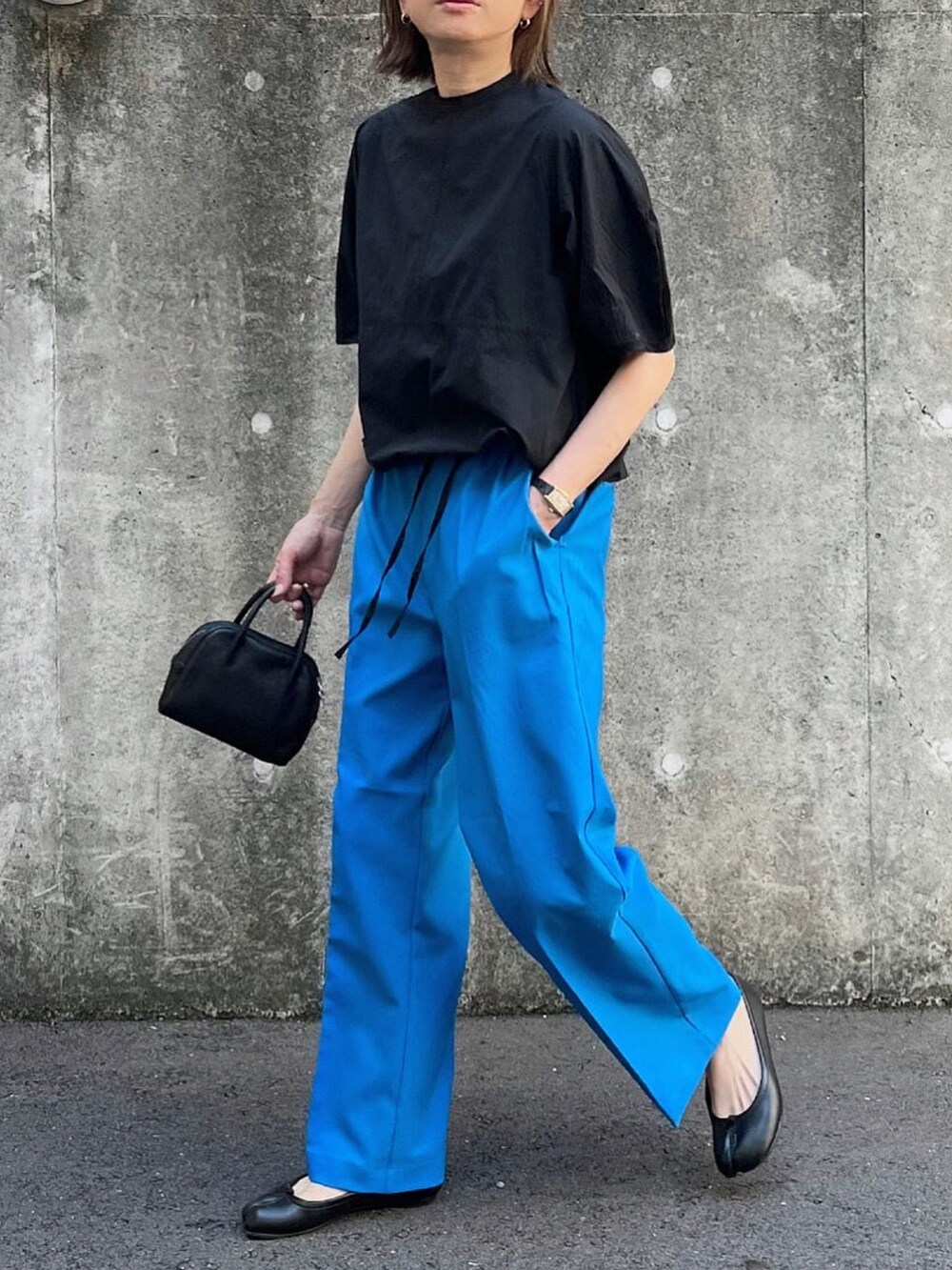 ブルー系のその他パンツ、ブラック系のシャツ/ブラウス、ブラック系のボストンバッグを着用したレディースの秋コーディネートの2枚目の写真