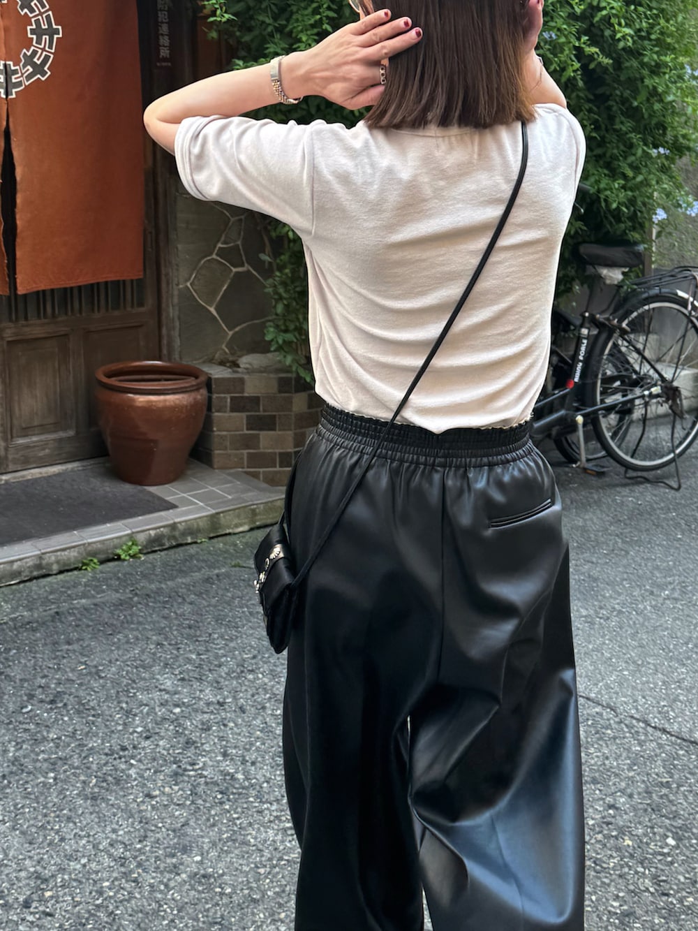 ベージュ系のTシャツ/カットソー、ブラック系のパンツ、ホワイト系のスニーカーを着用したレディースの夏コーディネートの2枚目の写真