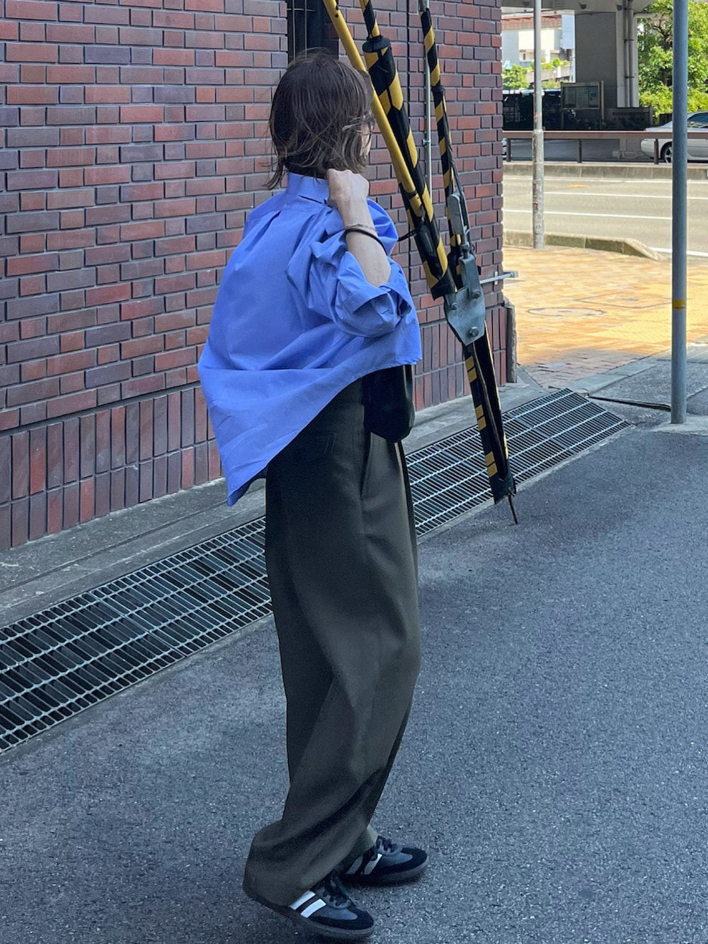 ブルー系のシャツ/ブラウス、グリーン系のパンツ、ブラック系のスニーカーを着用したレディースの夏コーディネートの5枚目の写真