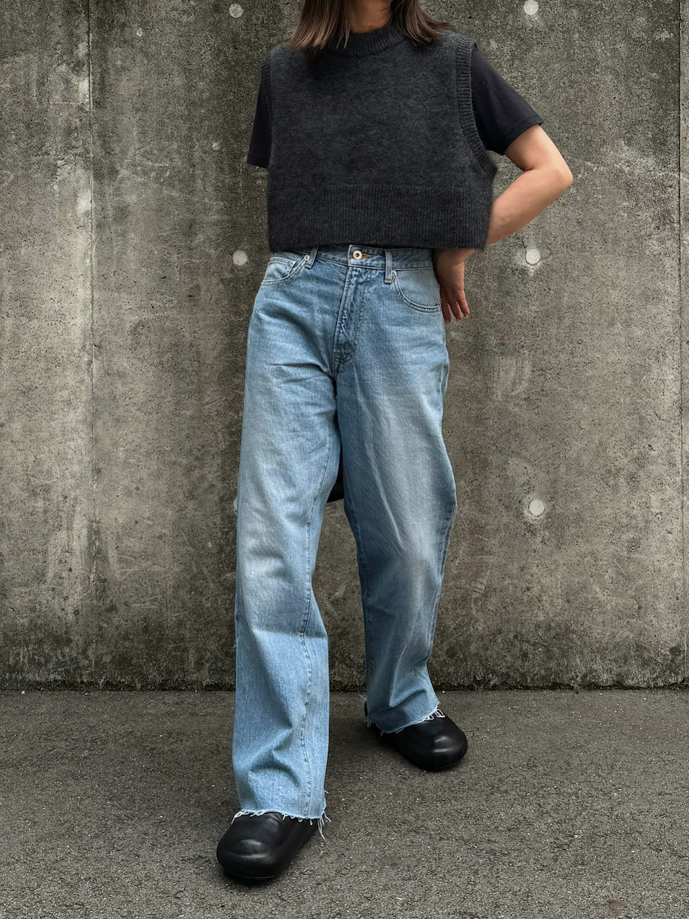 グレー系のニット/セーター、ブルー系のデニムパンツ、ブラック系のその他シューズを着用したレディースの夏コーディネートの4枚目の写真