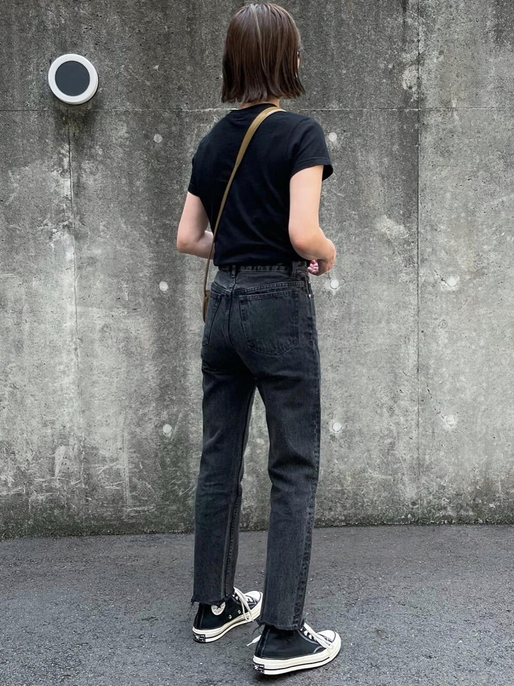 ブラウン系のショルダーバッグ、ブラック系のデニムパンツ、ブラック系のスニーカーを着用したレディースの夏コーディネートの3枚目の写真