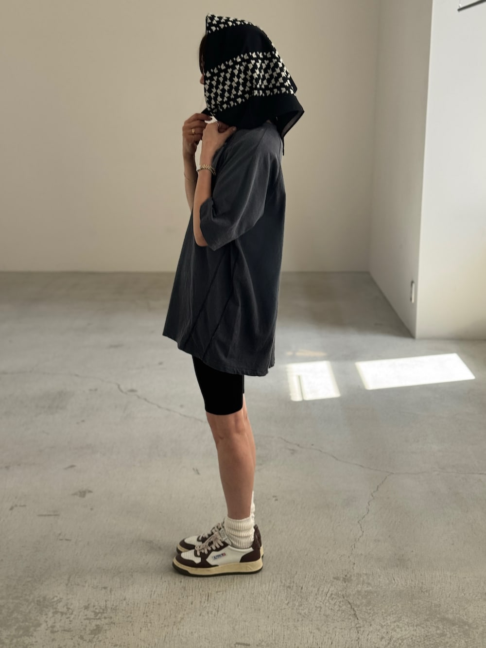 ブルー系のTシャツ/カットソー、ホワイト系のスニーカー、ブラック系のストール/ショールを着用したレディースの秋コーディネートの2枚目の写真