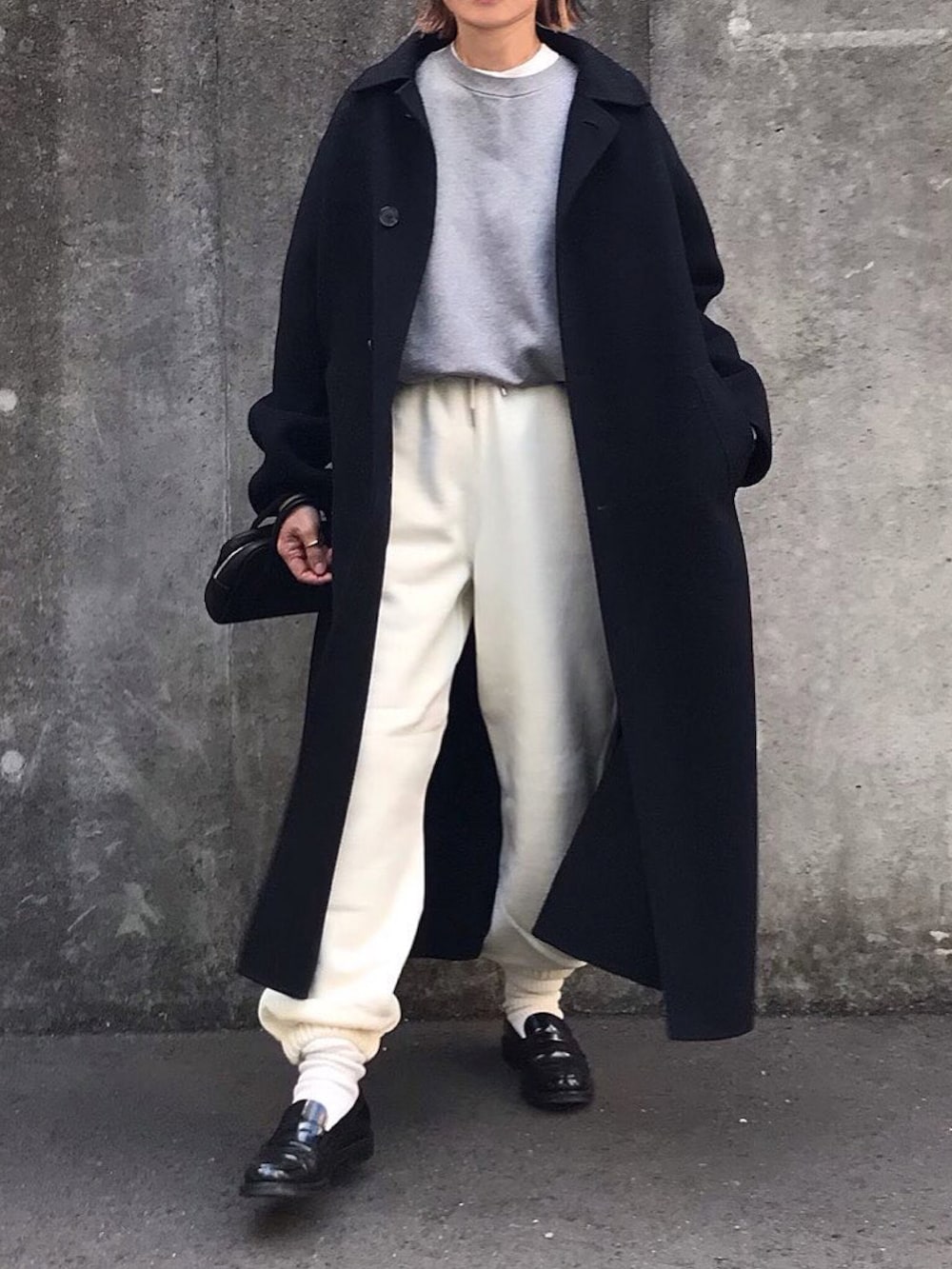 グレー系のスウェット、ホワイト系のスウェットパンツ、ブラック系のボストンバッグを着用したレディースの冬コーディネートの3枚目の写真