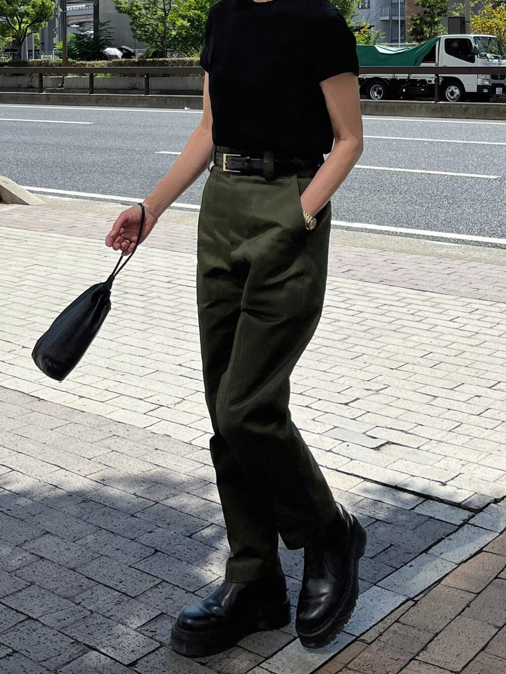 グリーン系のパンツ、ブラック系のブーツ、シルバー系のブレスレットを着用したレディースの秋コーディネートの3枚目の写真