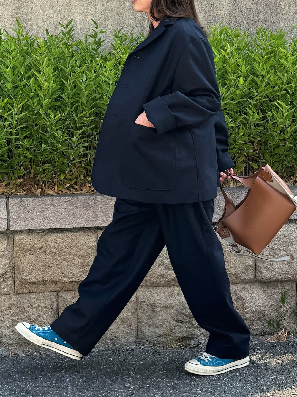 ブルー系のテーラードジャケット、ブルー系のスラックス、シルバー系のリングを着用したレディースの秋コーディネートの4枚目の写真