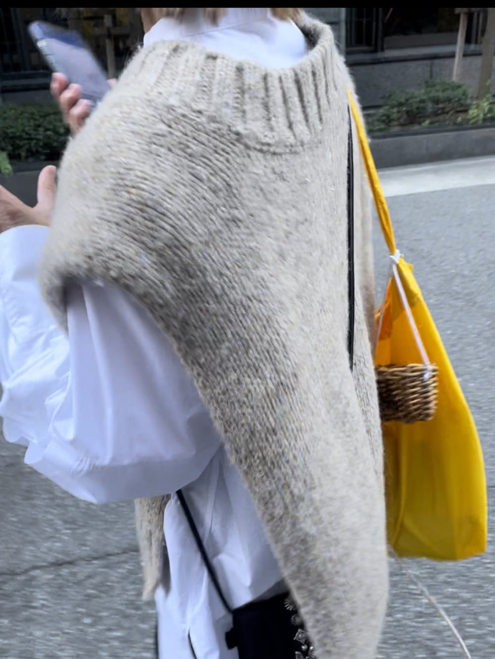 ブラック系のパンツ、ホワイト系のスニーカー、ベージュ系のキャップを着用したレディースの秋コーディネートの2枚目の写真